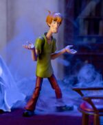 SHAGGY SCOOBY-DOO 1/12 ¡Prepárate para añadir a tu colección al ícono de los misterios y los sándwiches con la figura de acción de Scooby-Doo Shaggy a escala 1:12 de Jada Toys! Esta detallada pieza de colección captura al tranquilo pero adorable Norville "Shaggy" Rogers, el siempre hambriento mejor amigo de Scooby-Doo y miembro clave de Misterios S.A. Ya sea huyendo de fantasmas, resolviendo misterios (casi sin querer) o devorando un sándwich enorme, Shaggy siempre está listo para la aventura, ¡si no le da demasiado miedo! Diseñada por expertos a escala 1:12, esta figura luce la figura espigada de Shaggy, su característica camisa verde y sus clásicos pantalones de campana marrones. Gracias a su impresionante articulación, puedes colocarlo en diversas posturas expresivas, ya sea corriendo tras un fantasma espeluznante o sosteniendo una caja de Scooby Snacks. Este set incluye accesorios para resolver misterios, como cabezas y manos intercambiables para diferentes expresiones de terror y deleite, y una clásica caja de Scooby Snacks. Empaquetada en una caja premium inspirada en la estética clásica de Scooby-Doo, esta figura es imprescindible para los fans de la serie atemporal. Jada Toys mantiene su compromiso con la calidad y la nostalgia, asegurando que Shaggy esté listo para unirse a tu colección. ¡Solo asegúrate de tener muchos bocadillos a mano! Porque, seamos realistas... ¡siempre tiene hambre!