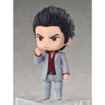 KAZUMA KIRYU YAKUZA NENDOROID. Se une a la colección Nendoroid de Good Smile Arts Shanghai la figura de Kazuma Kiryu. Mide 10 cm y está basada en el protagonista habitual de la saga de videojuegos "Yakuza".  Esta figura articulada incluye 3x placas faciales (seria, de batalla y cantando) y múltiples accesorios: 1x cigarrillo, 1x micrófono, 1x cono de tráfico, 1x base con soporte y otras partes opcionales para diferentes poses.  Puedes mostrarla junto a ICHIBAN KASUGA FIGURA 10 CM YAKUZA NENDOROID (se vende por separado).