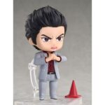 KAZUMA KIRYU YAKUZA NENDOROID. Se une a la colección Nendoroid de Good Smile Arts Shanghai la figura de Kazuma Kiryu. Mide 10 cm y está basada en el protagonista habitual de la saga de videojuegos "Yakuza".  Esta figura articulada incluye 3x placas faciales (seria, de batalla y cantando) y múltiples accesorios: 1x cigarrillo, 1x micrófono, 1x cono de tráfico, 1x base con soporte y otras partes opcionales para diferentes poses.  Puedes mostrarla junto a ICHIBAN KASUGA FIGURA 10 CM YAKUZA NENDOROID (se vende por separado).