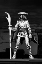 ELITE FOOT NINJA GUARD BLACK AND WHITE TEENAGE MUTANT NINJA TURTLES NECA. Basado en los cómics originales de Eastman & Laird de las Tortugas Ninja Adolescentes Mutantes de Mirage Studios.  Regresa a lo básico con la Guardia de Élite de Shredder, tal como apareció originalmente en la publicación en blanco y negro de Mirage Comics.  La Guardia de Élite, la más letal de los ninjas del Pie, está unida por honor a Shredder y es entrenada personalmente por él. Esta figura de acción mide 18 cm e incluye manos adicionales, lanza, sombrero y capa extraíble.  Viene en una caja con ventana especial con temática de cómic, ilustrada por Kevin Eastman.