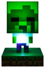 MINECRAFT LÁMPARA 3D ICON ZOMBIE. Con esta exclusiva lámpara de mesilla de la marca Paladone para su línea Icons tus noches serán mucho más pixeladas que de costumbre. La lamparita de 12 cms viene sobre una peana que parece césped de Minecraft. El pixelado cuerpo del zombie se iluminará y te acompañará cuando te desveles, pero recuerda, funciona con dos pilas AAA 1.5V no incluidas. Viene en una caja temática con ventana para que la colecciones junto a las otras lámparas de la colección: Álex, Steve y Creeper. Está hecho de plástico y es un producto de licencia oficial de Minecraft.