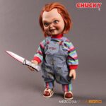 TALKING SNEERING CHUCKY CHILD’S PLAY. Mezco Toyz reincorpora a su colección MDS Mega Scale, esta figura parlante de Chucky en su versión más limpia y clásica, antes de que las cicatrices y el daño marcaran su rostro en las películas de la saga "Child’s Play" ("Muñeco diabólico" en España). Esta versión muestra a Chucky con su característico conjunto de los Good Guys, sin cortes ni desgastes, tal como sus primeras apariciones en pantalla. Mide 38 cm de alto, presenta 11 puntos de articulación, ojos con acabado vítreo realista y cabello naranja sintético. Viste ropa de tela auténtica y está equipada con un mecanismo de voz que reproduce en inglés varias frases icónicas del personaje, desde su famoso "My name is Chucky" hasta otras más siniestras.