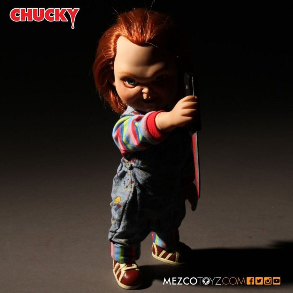 Talking sneering chucky child’s play. Mezco toyz reincorpora a su colección mds mega scale, esta figura parlante de chucky en su versión más limpia y clásica, antes de que las cicatrices y el daño marcaran su rostro en las películas de la saga "child’s play" ("muñeco diabólico" en españa). Esta versión muestra a chucky con su característico conjunto de los good guys, sin cortes ni desgastes, tal como sus primeras apariciones en pantalla. Mide 38 cm de alto, presenta 11 puntos de articulación, ojos con acabado vítreo realista y cabello naranja sintético. Viste ropa de tela auténtica y está equipada con un mecanismo de voz que reproduce en inglés varias frases icónicas del personaje, desde su famoso "my name is chucky" hasta otras más siniestras.