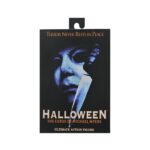 ULTIMATE MICHAEL MYERS HALLOWEEN: THE CURSE OF MICHAEL MYERS. Neca presenta la figura articulada Ultimate Michael Myers basada en la película "Halloween 6: The Curse of Michael Myers" ("Halloween 6: La maldición de Michael Myers" en España). Esta figura mide 18 cm e incluye 2x cabezas intercambiables, 1x máscara removible, 5x manos intercambiables, 1x hacha, 1x machete, 1x palanca, 2x cuchillos de cocina, 1x bolsa de runas, 4x velas de sacrificio, 1x conjunto de jeringas, 1x calabaza y 1x cartel de Strode Realty con la silueta de Michael Myers. Se presenta en una caja con ventana y tapa frontal abatible.