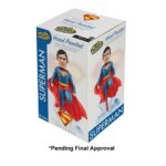 SUPERMAN 2025 DC UNIVERSE HEAD KNOCKER. Neca presenta la figura de Superman basada en el protagonista de la película homónima de 2025. Se muestra sobre una base translúcida de cristales de la Fortaleza de la Soledad, con su clásico traje azul y capa roja. Mide 21,5 cm, está fabricada con resina y pintada a mano con gran nivel de detalle. Cuenta con un mecanismo de resorte que permite el característico movimiento de cabeza de las figuras de la colección Head Knocker.