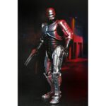 ULTIMATE ROBOCOP POSTER SERIES. Neca introduce en su línea Ultimate esta figura articulada de RoboCop, inspirada en el póster original de la película homónima de 1987.  Mitad hombre. Mitad máquina. ¡Pura policía! NECA se enorgullece de presentar la primera figura de acción de su nueva línea de figuras de acción Poster Series: una nueva figura de RoboCop basada en el clásico de culto. Esta figura articulada de 18 cm rinde homenaje al famoso póster de RoboCop de 1987, con una decoración especial que recrea el icónico arte del póster. Combate a criminales y droides renegados con una variedad de accesorios, como la pistola Auto-9, la mano con pico de datos intercambiable, el cañón de asalto Cobra y el efecto de disparo de pistola. Viene en una caja con ventana ideal para coleccionistas.