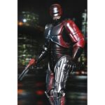 ULTIMATE ROBOCOP POSTER SERIES. Neca introduce en su línea Ultimate esta figura articulada de RoboCop, inspirada en el póster original de la película homónima de 1987.  Mitad hombre. Mitad máquina. ¡Pura policía! NECA se enorgullece de presentar la primera figura de acción de su nueva línea de figuras de acción Poster Series: una nueva figura de RoboCop basada en el clásico de culto. Esta figura articulada de 18 cm rinde homenaje al famoso póster de RoboCop de 1987, con una decoración especial que recrea el icónico arte del póster. Combate a criminales y droides renegados con una variedad de accesorios, como la pistola Auto-9, la mano con pico de datos intercambiable, el cañón de asalto Cobra y el efecto de disparo de pistola. Viene en una caja con ventana ideal para coleccionistas.