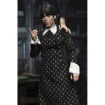 WEDNESDAY ADDAMS CLOTHED CLASSIC DRESS. Neca presenta la figura articulada de 20 cm de Wednesday Addams (conocida como Miércoles Addams en España), basada en su icónica aparición con vestido clásico en la serie de Netflix "Wednesday". La figura pertenece a la línea Clothed Action y está vestida con ropa de tela. Totalmente articulada, permite múltiples poses. Incluye 1x libro de Frankenstein, 2x set de manos intercambiables y 1x figura de Cosa.