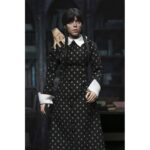 WEDNESDAY ADDAMS CLOTHED CLASSIC DRESS. Neca presenta la figura articulada de 20 cm de Wednesday Addams (conocida como Miércoles Addams en España), basada en su icónica aparición con vestido clásico en la serie de Netflix "Wednesday". La figura pertenece a la línea Clothed Action y está vestida con ropa de tela. Totalmente articulada, permite múltiples poses. Incluye 1x libro de Frankenstein, 2x set de manos intercambiables y 1x figura de Cosa.