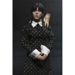WEDNESDAY ADDAMS CLOTHED CLASSIC DRESS. Neca presenta la figura articulada de 20 cm de Wednesday Addams (conocida como Miércoles Addams en España), basada en su icónica aparición con vestido clásico en la serie de Netflix "Wednesday". La figura pertenece a la línea Clothed Action y está vestida con ropa de tela. Totalmente articulada, permite múltiples poses. Incluye 1x libro de Frankenstein, 2x set de manos intercambiables y 1x figura de Cosa.