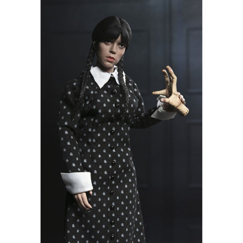 Wednesday addams clothed classic dress. Neca presenta la figura articulada de 20 cm de wednesday addams (conocida como miércoles addams en españa), basada en su icónica aparición con vestido clásico en la serie de netflix "wednesday". La figura pertenece a la línea clothed action y está vestida con ropa de tela. Totalmente articulada, permite múltiples poses. Incluye 1x libro de frankenstein, 2x set de manos intercambiables y 1x figura de cosa.