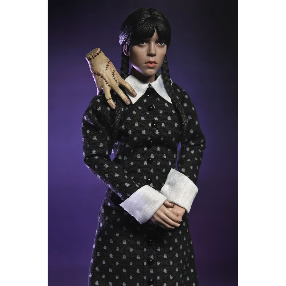 Wednesday addams clothed classic dress. Neca presenta la figura articulada de 20 cm de wednesday addams (conocida como miércoles addams en españa), basada en su icónica aparición con vestido clásico en la serie de netflix "wednesday". La figura pertenece a la línea clothed action y está vestida con ropa de tela. Totalmente articulada, permite múltiples poses. Incluye 1x libro de frankenstein, 2x set de manos intercambiables y 1x figura de cosa.