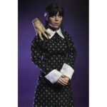 WEDNESDAY ADDAMS CLOTHED CLASSIC DRESS. Neca presenta la figura articulada de 20 cm de Wednesday Addams (conocida como Miércoles Addams en España), basada en su icónica aparición con vestido clásico en la serie de Netflix "Wednesday". La figura pertenece a la línea Clothed Action y está vestida con ropa de tela. Totalmente articulada, permite múltiples poses. Incluye 1x libro de Frankenstein, 2x set de manos intercambiables y 1x figura de Cosa.