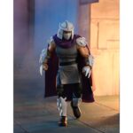 ULTIMATE SHREDDER (CLASSIC COLORS) TEENAGE MUTANT NINJA TURTLES CARTOON. Neca presenta la figura con colores clásicos de Ultimate Shredder, basada en la serie de televisión de los años 80 "Teenage Mutant Ninja Turtles". Esta figura mide 18 cm e incluye 2x cabezas intercambiables, 4x manos extras, 1x disquete, 1x arma, 1x collar, 1x paquete de billetes, 1x marco de foto y accesorios inspirados en episodios. Se presenta en una caja con ventana y tapa frontal abatible.
