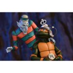 CREEPY EDDIE AND SHIBANO-SAMA TEENAGE MUTANT NINJA TURTLES CARTOON. Neca incorpora a su catálogo este set de figuras articuladas de Creepy Eddie y Shibano-Sama, basado en el cómic "Teenage Mutant Ninja Turtles: Saturday Morning Adventures". Ambas figuras tienen 18 cm de altura e incluyen 6x pares de manos intercambiables, 1x katana, 2x partes inferiores fantasmales, 1x par de tirantes removibles de Creepy Eddie, 1x casco Dream-O-Vision (compatible con la mayoría de las figuras de esta colección), y otros accesorios. El set incorpora una base de exposición con brazo articulado oficial de Neca. Presentado en una caja ilustrada con ventana.