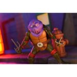 ULTIMATE DARK LEO TEENAGE MUTANT NINJA TURTLES CARTOON. Neca suma a su colección la figura articulada Ultimate Dark Leo, la versión oscura de Leonardo tras cruzar el portal de Donatello y caer bajo el control de Shredder. Basada en el número 20 del cómic "Teenage Mutant Ninja Turtles: Saturday Morning Adventures", esta figura viene con varios accesorios: 2x espadas, 1x maza, 4x manos intercambiables, 1x máscara de control mental compatible con otras figuras (se venden por separado) y 1x lámina hoolográfica para recrear el portal. Mide aproximadamente 18 cm y se presenta en una caja ilustrada con ventana y tapa abatible.