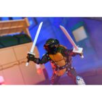 ULTIMATE DARK LEO TEENAGE MUTANT NINJA TURTLES CARTOON. Neca suma a su colección la figura articulada Ultimate Dark Leo, la versión oscura de Leonardo tras cruzar el portal de Donatello y caer bajo el control de Shredder. Basada en el número 20 del cómic "Teenage Mutant Ninja Turtles: Saturday Morning Adventures", esta figura viene con varios accesorios: 2x espadas, 1x maza, 4x manos intercambiables, 1x máscara de control mental compatible con otras figuras (se venden por separado) y 1x lámina hoolográfica para recrear el portal. Mide aproximadamente 18 cm y se presenta en una caja ilustrada con ventana y tapa abatible.