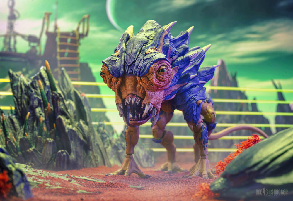 Cosmic legions: oxkrewe book one thraxxon lowland scapeback (deluxe creature). Los escapós se encuentran por todo thraxxon, con diferentes variantes de esta especie adaptadas para sobrevivir en las zonas específicas del planeta donde habitan. Originario de los duros valles de thraxxon, el escapós de las tierras bajas es la clasificación más agresiva de esta raza. Los escapós de las tierras bajas poseen placas de armadura pesadas y espinas afiladas que recorren su cuerpo. Esta armadura los protege y les permite mimetizarse perfectamente con el paisaje del planeta mientras hibernan para conservar energía, emergiendo solo cuando creen que hay una posible presa cerca. Las vibraciones causadas por explosivos en el perímetro del campamento de la oxkrewe despiertan a una manada de escapós de las tierras bajas. Enfurecidos y voraces, los escapós entran en un frenesí alimenticio y atacan el campamento, atravesando fácilmente las defensas perimetrales, que no hacen nada contra las pieles acorazadas de las bestias. Es solo la intervención del veebliano llamado ukha, junto con un grupo de exploradores thraxxianos, lo que salva al oxkrewe de convertirse en la próxima comida de los fugitivos.