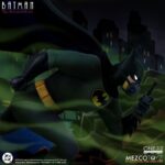 BATMAN: THE ANIMATED SERIES ONE:12 COLLECTIVE. Captura al Caballero Oscuro en su estilo animado característico, inspirado en la estética de arte noir de la serie innovadora. Se incluye una capa con un alambre de posado integrado y tres retratos de cabeza intercambiables con diferentes expresiones faciales, lo que permite una variedad de looks distintos de la serie. Cuando la noche exige más que solo habilidad y fuerza, Batman viene equipado con gafas de visión infrarroja para una mejor visibilidad, una máscara de rebreather para actividades submarinas, un control remoto para convocar al Batmóvil y muchas más herramientas para combatir el crimen. Batman: La Serie Animada sigue al Caballero Oscuro mientras patrulla las calles plagadas de crimen de Gotham, mientras lucha con su doble identidad como Bruce Wayne y la pérdida de sus padres.