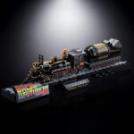 TIME TRAIN BACK TO THE FUTURE III CHOGOKIN. Presenta dentro de la línea Chogokin la máquina del tiempo con forma de locomotora de vapor que inventa el Dr. Emmett Brown en la película de 1990 "Back to the Future Part III" (o "Regreso al Futuro III" en España). Esta reproducción coleccionable que conmemora el 40º aniversario de la primera película está fabricada con ABS, PVC y metal, y tiene una longitud de 48 cm. La base que recrea una vía de tren alcanza los 56 cm de largo y está decorada con el logotipo oficial de la película. Además, cuenta con un mecanismo que gira las ruedas y eleva el vehículo. Al añadir las alas incluidas como accesorio se completa el aspecto de la máquina del tiempo en modo vuelo. Los LED bajo la locomotora y de la parte posterior se iluminan recreando el efecto de propulsión de la película. Algunas piezas se activan con electricidad como los engranajes de la locomotora que giran y cambian de dirección o la luz blanca del lateral que se enciende como en el filme. La puerta del conductor se abre hacia arriba, dejando al descubierto el interior de la cabina que se ha esculpido en base a documentación oficial. Se incluyen las figuras de los personajes que aparecen en la misma secuencia de la película y cuentan con una altura aproximada de 4 cm. La fuente de alimentación principal y el conector USB-C están situados en un extremo de la base, lo que elimina la necesidad de pilas para alimentar los diferentes mecanismos y las 56 luces LED. Se incluye un cable USB Type-A, pero no un adaptador USB. UNIDADES LIMITADAS.
