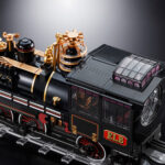 TIME TRAIN BACK TO THE FUTURE III CHOGOKIN. Presenta dentro de la línea Chogokin la máquina del tiempo con forma de locomotora de vapor que inventa el Dr. Emmett Brown en la película de 1990 "Back to the Future Part III" (o "Regreso al Futuro III" en España). Esta reproducción coleccionable que conmemora el 40º aniversario de la primera película está fabricada con ABS, PVC y metal, y tiene una longitud de 48 cm. La base que recrea una vía de tren alcanza los 56 cm de largo y está decorada con el logotipo oficial de la película. Además, cuenta con un mecanismo que gira las ruedas y eleva el vehículo. Al añadir las alas incluidas como accesorio se completa el aspecto de la máquina del tiempo en modo vuelo. Los LED bajo la locomotora y de la parte posterior se iluminan recreando el efecto de propulsión de la película. Algunas piezas se activan con electricidad como los engranajes de la locomotora que giran y cambian de dirección o la luz blanca del lateral que se enciende como en el filme. La puerta del conductor se abre hacia arriba, dejando al descubierto el interior de la cabina que se ha esculpido en base a documentación oficial. Se incluyen las figuras de los personajes que aparecen en la misma secuencia de la película y cuentan con una altura aproximada de 4 cm. La fuente de alimentación principal y el conector USB-C están situados en un extremo de la base, lo que elimina la necesidad de pilas para alimentar los diferentes mecanismos y las 56 luces LED. Se incluye un cable USB Type-A, pero no un adaptador USB. UNIDADES LIMITADAS.