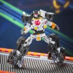BONE SHAKER TRANSFORMERS COLLABORATIVE HOT WEELS X TRANSFORMERS. Hasbro añade a su colección Transformers Collaborative esta figura del icónico vehículo Bone Shaker de la marca Hot Wheels. Mide 12,5 cm y se convierte de vehículo a robot en 22 pasos. En el modo coche cuenta con una intimidante decoración de llamas y su inconfundible parachoques frontal con forma de calavera. Incluye 1x palanca de cambios con forma de maza que puede fijarse en ambos modos y que le proporciona un aspecto amenazante. UNIDADES LIMITADAS.