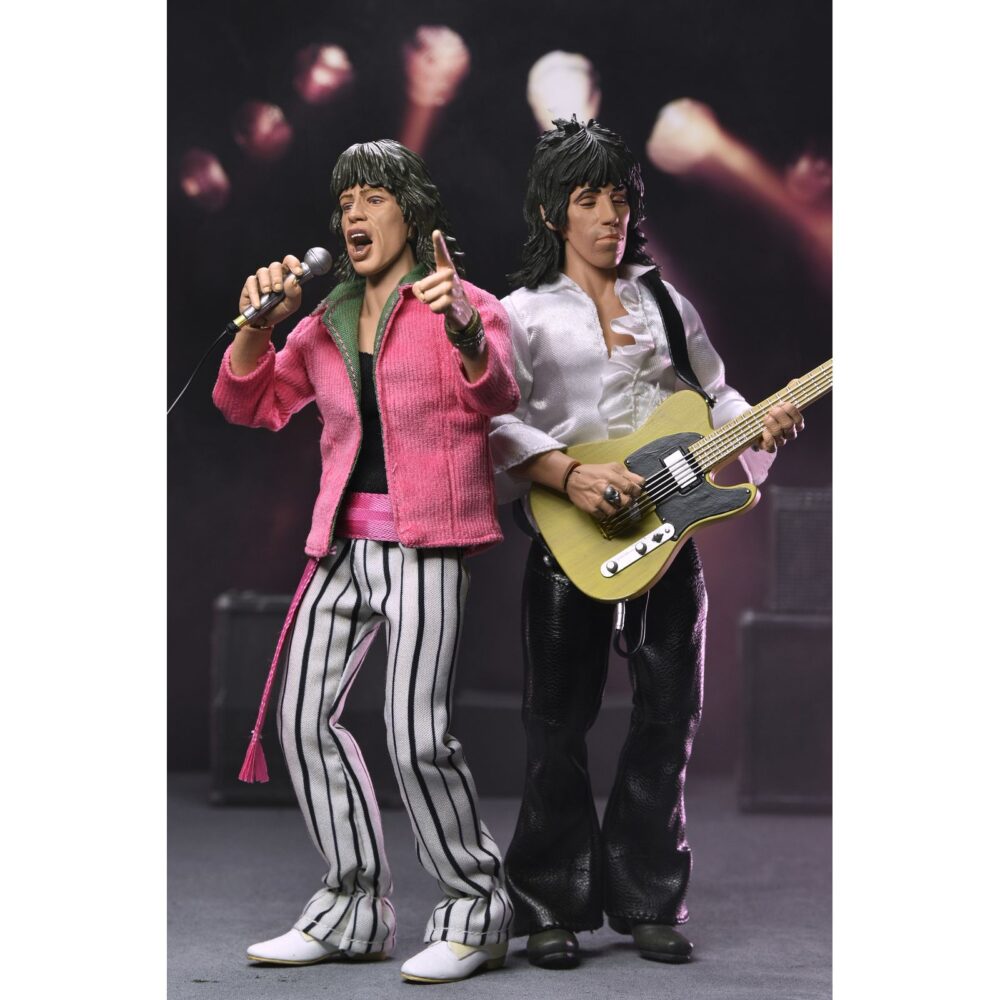 Mick jagger the rolling stones 1975. Neca suma a su colección chothed action esta figura articulada de mick jagger inspirada en el aspecto que solía lucir el cantante de "the rolling stones" en los conciertos de los 70. Mide2 0 cm de alto y cuenta con ropa a medida. Incluye 1x placa facial adicional, 1x mano intercambiable, 1x disco del álbum "sticky fingers" con su correspodiente funda y 1x micrófono con pie. Se presenta en una caja con ventana.