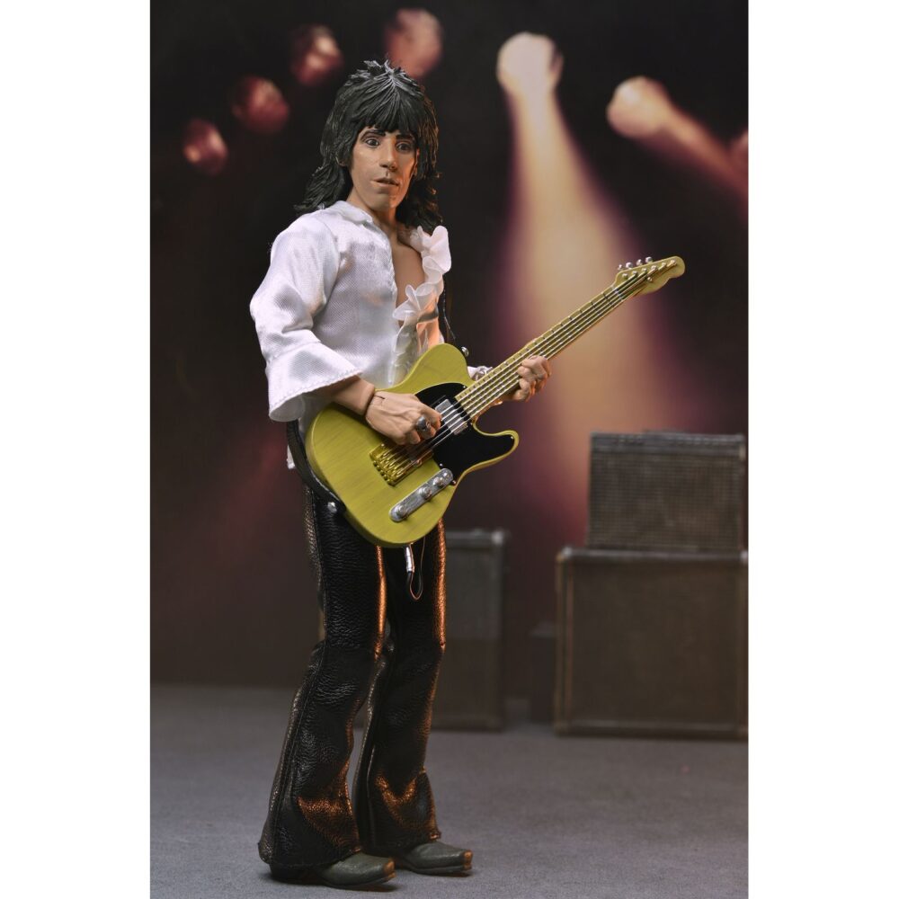 KEITH RICHARDS THE ROLLING STONES 1975. Neca añade a su colección Chothed Action esta figura articulada de Keith Richards inspirada en el aspecto que solía lucir el guitarrista de "The Rolling Stones" en los conciertos de los 70. La figura mide 20 cm y cuenta con ropa a medida. Incluye 1x placa facial adicional, 1x guitarra Fender y 1x disco del álbum "Let it Bleed" con su correspodiente funda. Se presenta en una caja con ventana.