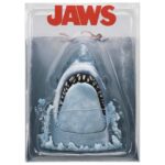 JAWS 50TH ANNIVERSARY POSTER SERIES DISPLAY. Con motivo del 50 aniversario de su estreno, Neca presenta este diorama que reproduce el icónico póster pintado por Roger Kastel de la película de 1975 “Jaws” (“Tiburón” en España). El tiburón del diorama cuenta con una mandíbula articulada y emerge de una base que imita el agua con burbujas esculpidas para atacar a la indefensa bañista de la superficie. Se presenta en una caja con ventana transparente y con con un fondo que recrea el póster clásico.
