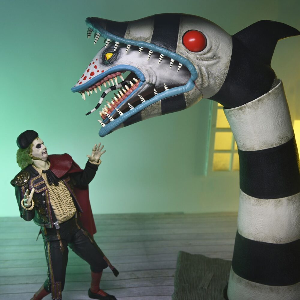 Ultimate “matador” beetlejuice y sandworm. Neca incorpora a su colección ultimate scale action este pack de 2 figuras articuladas de bitelchús y del gusano de arena, basadas en los personajes de la película del 2024 de tim burton "beetlejuice beetlejuice" ("bitelchús bitelchús" en españa). La figura del protagonista con su traje de torero mide aproximadamente 18 cm de alto, mientras que la del gusano de arena tiene 30,5 cm de altura y cuenta con una base imitando el suelo roto de la iglesia. Se incluye 1x capa de tela, 1x placa facial y 2x manos para la figura de bitelchús. Se presentan en una caja ilustrada con ventana.