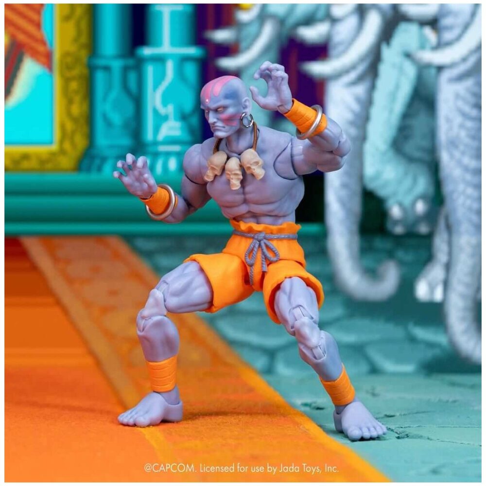 Dhalsim deluxe player 2 exclusive ultra street fighter ii. Jada toys presenta esta figura de dhalsim. Mide 17 cm y está basada en su aparición en los videojuegos de "street fighter". Fabricada por expertos a escala 1:12, esta figura da vida al maestro del yoga con una articulación increíble, extremidades flexibles únicas y efectos de fuego. Tanto si adopta una postura meditativa como si despliega su devastadora llama del yoga, esta versión de dhalsim es imprescindible para los coleccionistas serios de street fighter. Este set de lujo incluye todo lo necesario para encarnar su trascendental estilo de combate: (3) esculturas de cabeza en total, incluyendo una nueva expresión exclusiva para este lanzamiento, (1) escultura de cabeza extra para tu dhalsim jugador 1, (3) juegos de manos, (2) piernas flexibles, (2) brazos flexibles, accesorio de cuerpo en llamas con soporte de exhibición, (1) pieza de efecto yoga fuego y (1) pieza de efecto yoga llama. Esta figura de dhalsim se presenta en una caja de coleccionista con un escaparate transparente y es ideal tanto para los coleccionistas que la reciben dentro de la caja como para los que la sacan de ella. El embalaje también incluye una funda extraíble adornada con vibrantes ilustraciones de los personajes, lo que la convierte en una pieza destacada para cualquier exposición de street fighter. Unidades limitadas.