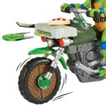 DRIVE N KICK LEONARDO & MOTOCICLETA NINJA TURTLES: CAOS MUTANTE FIGURA. Cuando los malos se descontrolan y vuelven a causar el caos en la ciudad, las Tortugas envían a Leo y su Ninja Kick Cycle a resolver el problema. Leo llega al lugar en un santiamén y ¡listo para luchar! Cuando aparece un villano, Leo salta de su asiento y se balancea de lado a lado para derrotar al malo. Si la patada no es suficiente para derrotar a los malos, Leo se dirige hacia ellos y dispara una de sus poderosas estrellas arrojadizas. ¡Problema resuelto! AUTÉNTICO: El poderoso Ninja Kick Cycle con tubos de escape dobles está auténticamente detallado y viene con una exclusiva figura de acción de Leonardo con casco desmontable. FUNCIÓN DE LUCHA: ¡Gira la porción de pizza de un lado a otro y observa cómo Leo salta de su asiento y patea de un lado a otro para derribar a los malos! EXTREMADAMENTE MÓVIL: La exclusiva figura de acción de Leonardo Básico mide 11,4 cm de alto y tiene 12 puntos de articulación para conseguir poses de lucha llenas de acción ACCESORIOS: El set incluye las katanas características de Leo, una funda y un lanzador de estrellas ninja.