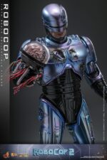 ROBOCOP 2 MOVIE MASTERPIECE HOT TOYS 1/6. Es considerada una película clásica de acción y ciencia ficción, muy querida por muchos fans. La historia sigue a RoboCop, un agente de la ley cíborg que antes era un humano llamado Alex Murphy. Tras ser brutalmente asesinado en acto de servicio, se transforma en un poderoso robot de alta tecnología con habilidades avanzadas. Posee superfuerza, visión mejorada y un compromiso inquebrantable con la ley. En "RoboCop 2", RoboCop continúa protegiendo a los ciudadanos de Detroit. Se enfrenta a una nueva amenaza cuando un ejecutivo rebelde de OCP desarrolla una versión más avanzada y malévola de RoboCop, lo que supone un grave desafío para su misión y la seguridad de la ciudad.