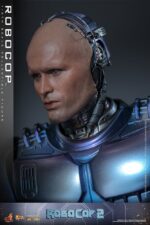 ROBOCOP 2 MOVIE MASTERPIECE HOT TOYS 1/6. Es considerada una película clásica de acción y ciencia ficción, muy querida por muchos fans. La historia sigue a RoboCop, un agente de la ley cíborg que antes era un humano llamado Alex Murphy. Tras ser brutalmente asesinado en acto de servicio, se transforma en un poderoso robot de alta tecnología con habilidades avanzadas. Posee superfuerza, visión mejorada y un compromiso inquebrantable con la ley. En "RoboCop 2", RoboCop continúa protegiendo a los ciudadanos de Detroit. Se enfrenta a una nueva amenaza cuando un ejecutivo rebelde de OCP desarrolla una versión más avanzada y malévola de RoboCop, lo que supone un grave desafío para su misión y la seguridad de la ciudad.