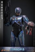 ROBOCOP 2 MOVIE MASTERPIECE HOT TOYS 1/6. Es considerada una película clásica de acción y ciencia ficción, muy querida por muchos fans. La historia sigue a RoboCop, un agente de la ley cíborg que antes era un humano llamado Alex Murphy. Tras ser brutalmente asesinado en acto de servicio, se transforma en un poderoso robot de alta tecnología con habilidades avanzadas. Posee superfuerza, visión mejorada y un compromiso inquebrantable con la ley. En "RoboCop 2", RoboCop continúa protegiendo a los ciudadanos de Detroit. Se enfrenta a una nueva amenaza cuando un ejecutivo rebelde de OCP desarrolla una versión más avanzada y malévola de RoboCop, lo que supone un grave desafío para su misión y la seguridad de la ciudad.