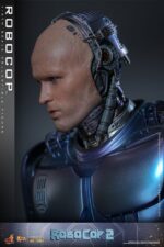 ROBOCOP 2 MOVIE MASTERPIECE HOT TOYS 1/6. Es considerada una película clásica de acción y ciencia ficción, muy querida por muchos fans. La historia sigue a RoboCop, un agente de la ley cíborg que antes era un humano llamado Alex Murphy. Tras ser brutalmente asesinado en acto de servicio, se transforma en un poderoso robot de alta tecnología con habilidades avanzadas. Posee superfuerza, visión mejorada y un compromiso inquebrantable con la ley. En "RoboCop 2", RoboCop continúa protegiendo a los ciudadanos de Detroit. Se enfrenta a una nueva amenaza cuando un ejecutivo rebelde de OCP desarrolla una versión más avanzada y malévola de RoboCop, lo que supone un grave desafío para su misión y la seguridad de la ciudad.