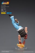 RALF JONES THE KING OF FIGHTERS’98 HERO TEAM. JoyToy x SNK presentan la figura de acción de Ralf Jones de la serie «The King of Fighters '98», tamaño aprox. 12 cm. Esta figura de acción a escala 1/12 presenta el robusto diseño militar, la musculatura y el característico pañuelo rojo de Ralf. Con una articulación dinámica y accesorios detallados para las armas, esta figura es perfecta para los fans que quieren exhibir todo su poder.