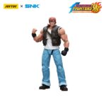 RALF JONES THE KING OF FIGHTERS’98 HERO TEAM. JoyToy x SNK presentan la figura de acción de Ralf Jones de la serie «The King of Fighters '98», tamaño aprox. 12 cm. Esta figura de acción a escala 1/12 presenta el robusto diseño militar, la musculatura y el característico pañuelo rojo de Ralf. Con una articulación dinámica y accesorios detallados para las armas, esta figura es perfecta para los fans que quieren exhibir todo su poder.