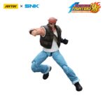 RALF JONES THE KING OF FIGHTERS’98 HERO TEAM. JoyToy x SNK presentan la figura de acción de Ralf Jones de la serie «The King of Fighters '98», tamaño aprox. 12 cm. Esta figura de acción a escala 1/12 presenta el robusto diseño militar, la musculatura y el característico pañuelo rojo de Ralf. Con una articulación dinámica y accesorios detallados para las armas, esta figura es perfecta para los fans que quieren exhibir todo su poder.