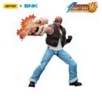 RALF JONES THE KING OF FIGHTERS’98 HERO TEAM. JoyToy x SNK presentan la figura de acción de Ralf Jones de la serie «The King of Fighters '98», tamaño aprox. 12 cm. Esta figura de acción a escala 1/12 presenta el robusto diseño militar, la musculatura y el característico pañuelo rojo de Ralf. Con una articulación dinámica y accesorios detallados para las armas, esta figura es perfecta para los fans que quieren exhibir todo su poder.