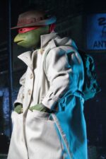 RAPHAEL IN DISGUISE TEENAGE MUTANT NINJA TURTLES 1/4. Figuras: 30 cm Tortugas Ninja "¿Un bate de José Canseco? Dime... no pagaste por esto." La nueva figura de acción a escala 1/4 de NECA, de la película de las Tortugas Ninja de 1990, es Raphael disfrazado para pasar desapercibido por la ciudad. Lleva una gabardina de tela, un sombrero esculpido y una mochila, todos extraíbles. Raphael mide 42 cm de alto y cuenta con 30 puntos de articulación, incluyendo codos dobles, para demostrar plenamente su dominio de las artes marciales. La figura es muy detallada y fiel a la película, e incluye un bate de béisbol, una rebanada de pizza y accesorios sai, además de manos intercambiables.