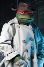 RAPHAEL IN DISGUISE TEENAGE MUTANT NINJA TURTLES 1/4. Figuras: 30 cm Tortugas Ninja "¿Un bate de José Canseco? Dime... no pagaste por esto." La nueva figura de acción a escala 1/4 de NECA, de la película de las Tortugas Ninja de 1990, es Raphael disfrazado para pasar desapercibido por la ciudad. Lleva una gabardina de tela, un sombrero esculpido y una mochila, todos extraíbles. Raphael mide 42 cm de alto y cuenta con 30 puntos de articulación, incluyendo codos dobles, para demostrar plenamente su dominio de las artes marciales. La figura es muy detallada y fiel a la película, e incluye un bate de béisbol, una rebanada de pizza y accesorios sai, además de manos intercambiables.
