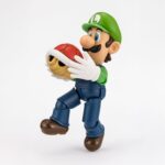 LUIGI SUPER MARIO SH FIGUARTS.Tamashii suma a su colección S.H. Figuarts esta figura articulada de Luigi, basada en su personaje en la serie de videojuegos "Super Mario Bros". Con una altura aproximada de 11 cm, está diseñada para capturar sus características y variadas poses. Incluye 1x bloque de ladrillos, 1x caparazón rojo Akakora, 1x base de exhibición especial con su emblema, 2x manos intercambiables y 1x set de piezas de articulación para el caparazón rojo. Fabricada en ABS/PVC.