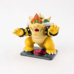 BOWSER SUPER MARIO SH FIGUARTS. Tamashii vuelve a presentar esta figura de Bowser, dentro de la colección S.H. Figuarts inspirada en "Super Mario Bros". Mide aproximadamente 13 cm y cuenta con múltiples puntos de articulación para exhibirlo en poses imponentes. Incluye 2x mandíbulas inferiores intercambiables, 2x manos adicionales y 1x soporte con su logotipo. Fabricada en ABS/PVC.