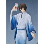 OSAMU DAZAI: KIMONO VERSION BUNGO STRAY DOGS 1/7. Good Smile Arts Shanghai presenta la figura del detective Osamu Dazai con kimono, Inspirada en el anime "Bungo Stray Dogs". Se ha aplicado una suave degradado para proporcionar a las mangas y al dobladillo un aspecto similar al de una pintura en tinta. Mide aproximadamente 23 cm de alto a escala 1/7. La base está decorada con detalles típicos japoneses, como el puente rojo de madera y las hojas otoñales.