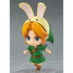 LINK THE LEGEND OF ZELDA MAJORA’S MASK NENDOROID. Good Smile Company vuelve a introducir en su colección Nendoroid la figura articulada de Link basada en el protagonista del videojuego "The Legend of Zelda: Majora's Mask 3D" para Nintendo 3DS. Esta edición cuenta con una selección de accesorios mayor de lo habitual: 2x placas faciales intercambiables (sonriente y gritando), 1x escudo del Héroe, 1x espada Kokiri, 1x poción de salud, 1x capucha de conejo, 1x Máscara Deku, 1x Máscara Goron, 1x Máscara Zora, 1x Máscara de Majora y 1x hada Tatl con soporte. Mide aproximadamente 10 cm de altura y está fabricada en PVC y ABS. Se presenta en caja con ventana y cuenta con una base cuadrada transparente con soporte articulado para exposición.