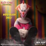 SLIM PELUCHE KILLER CLOWNS FROM OUTER SPACE MDS ROTO PLUSH. Mezco Toyz presenta dentro de su colección MDS Roto Plush este muñeco de peluche de Slim, el payaso extraterrestre experto en diversión mortal de la película de culto "Killer Klowns from Outer Space" ("Los payasos asesinos del espacio exterior" en España). Mide aproximadamente 46 cm de altura y reproduce sus rasgos caricaturescos con un acabado siniestro. Usa un traje de color rosa intenso con detalles bordados de luna creciente, cabeza esculpida con facciones exageradas y cabello naranja encendido. Cuenta con su nariz roja abultada y su perturbadora sonrisa. Se presenta en una caja con ventana troquelada perfecta para exhibición.