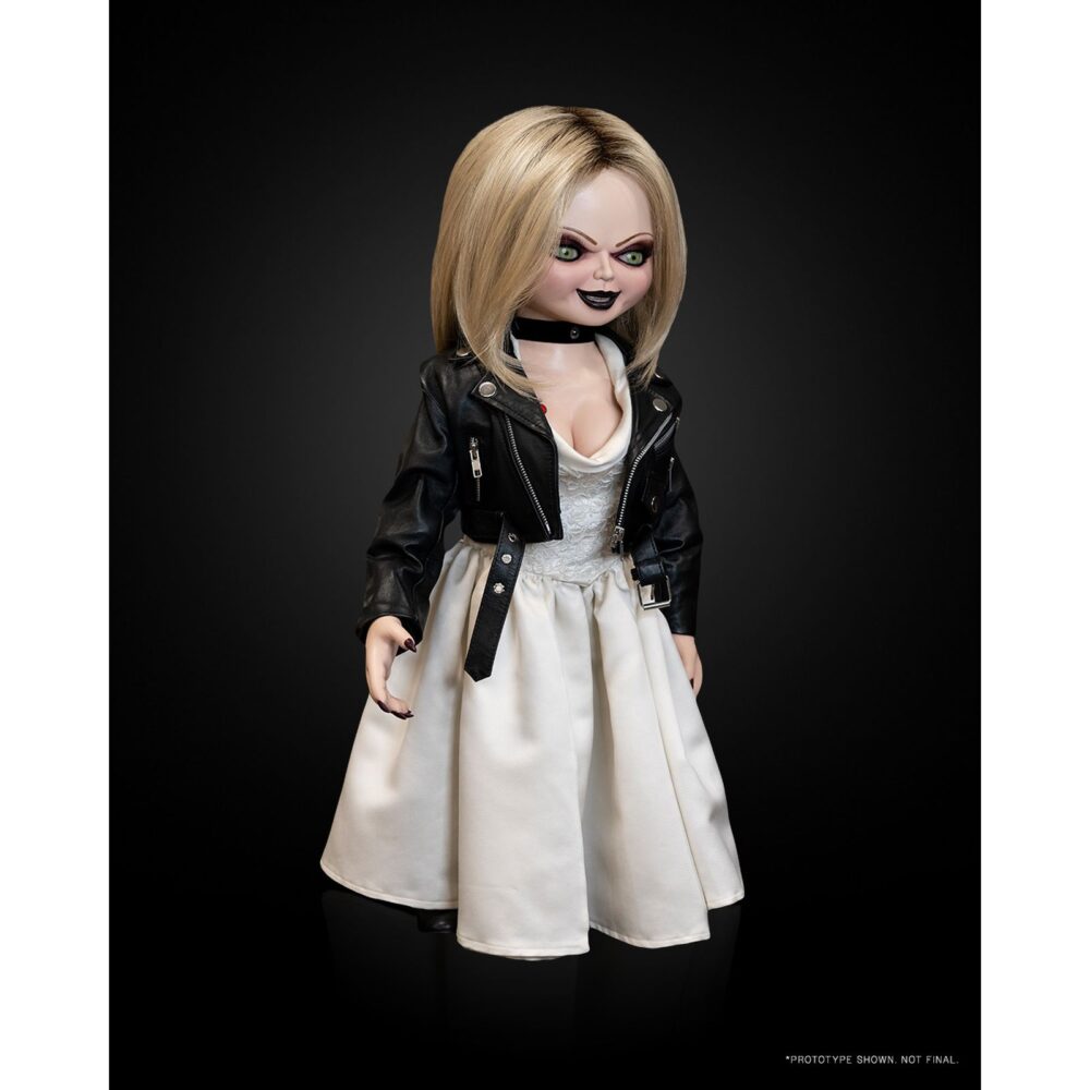 Tiffany chucky tv series réplica doll 1/1. Neca presenta la réplica oficial a escala 1:1 de tiffany, tal como aparece en la serie de tv "chucky". Desarrollada junto al estudio alterian inc. Y al creador del personaje, tony gardner, esta muñeca de tamaño real reproduce con precisión todos los detalles vistos en pantalla. Cuenta con estructura interna que permite reproducir diversas poses, ojos giratorios, cabello realista, chaqueta y vestido de novia confeccionados a medida. Mide aproximadamente 60 cm de alto y se presenta en una caja con ventana réplica de good gals.