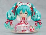 HATSUNE MIKU 15TH ANNIVERSARY NENDOROID. Good Smile suma a su catálogo Nendoroid la figura articulada de la cantante virtual de Vocaloid "Hatsune Miku" basada en la ilustración de En Morikura para conmemorar el 15º aniversario de personaje donde lleva un atuendo basado en una tarta de fresa. Cuenta con 3x placas faciales (estándar, sonriente y satisfecha), 1x tenedor, 1x macaron y 1x base con forma de plato conmemorativo. Mide aproximadamente 10 cm de altura e incluye base con soporte transparente para su exposición.
