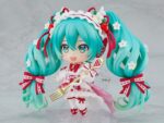 HATSUNE MIKU 15TH ANNIVERSARY NENDOROID. Good Smile suma a su catálogo Nendoroid la figura articulada de la cantante virtual de Vocaloid "Hatsune Miku" basada en la ilustración de En Morikura para conmemorar el 15º aniversario de personaje donde lleva un atuendo basado en una tarta de fresa. Cuenta con 3x placas faciales (estándar, sonriente y satisfecha), 1x tenedor, 1x macaron y 1x base con forma de plato conmemorativo. Mide aproximadamente 10 cm de altura e incluye base con soporte transparente para su exposición.
